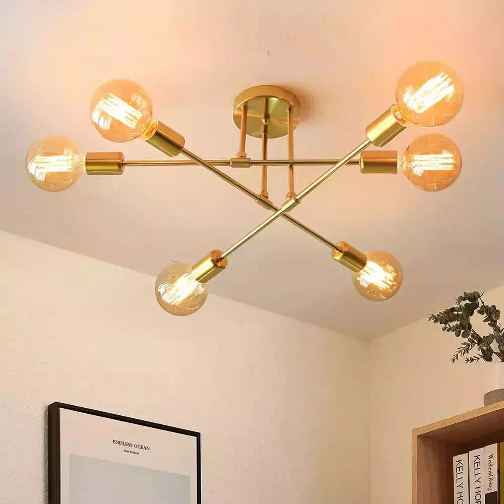 Gros plan du plafonnier doré et de ses ampoules à filament, structure croisée.