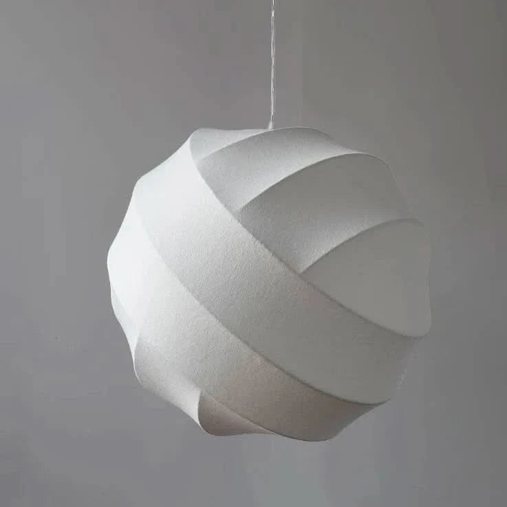 Même luminaire en version blanche, légèrement allumé, sur fond de mur gris