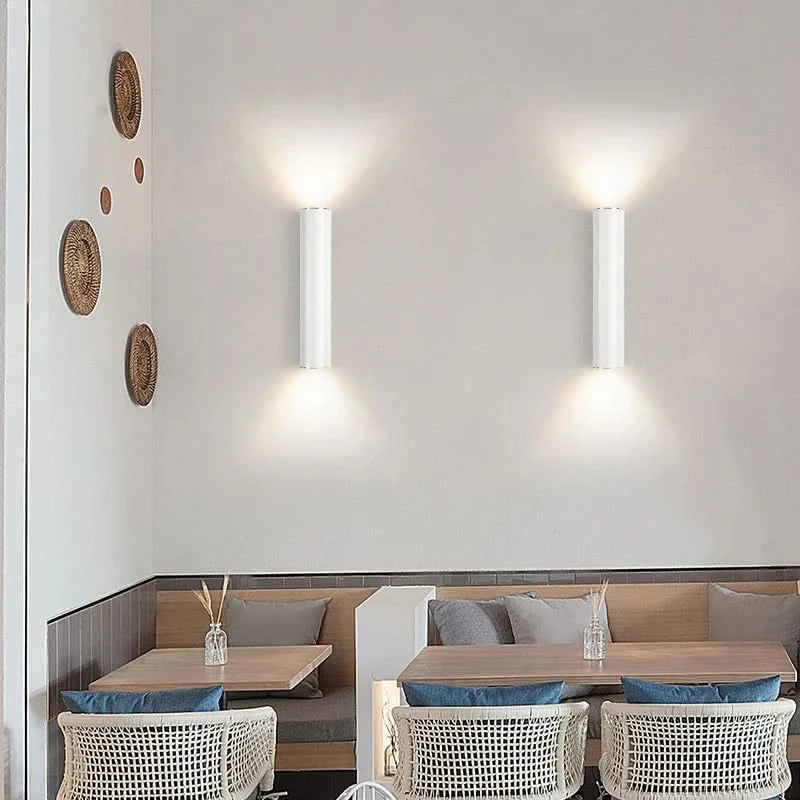 Mise en ambiance restaurant : deux appliques blanches éclairent une banquette