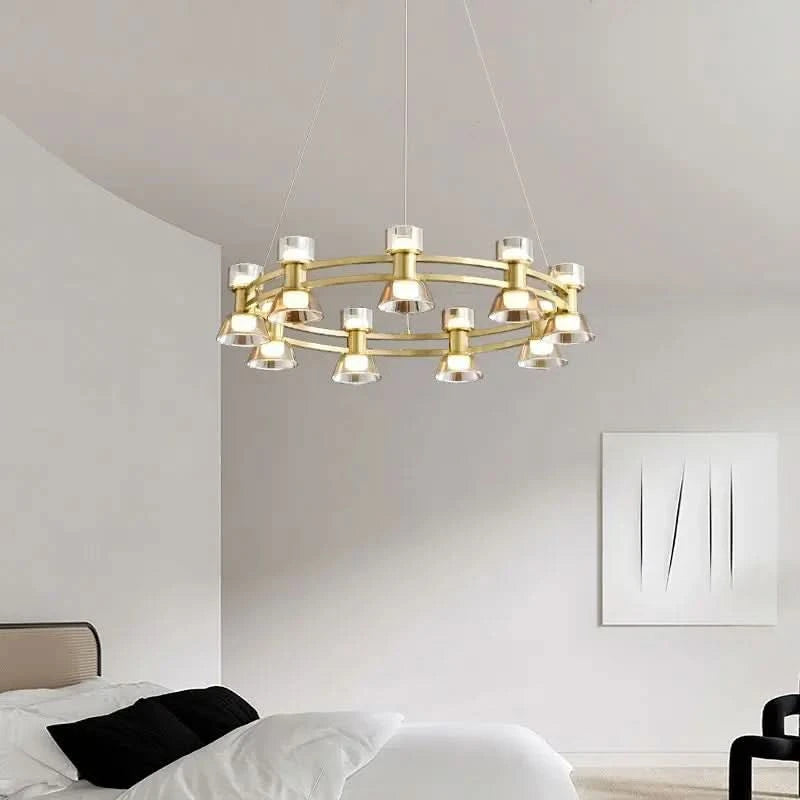 Plafonnier doré à deux anneaux éclairant une chambre blanche au-dessus du lit