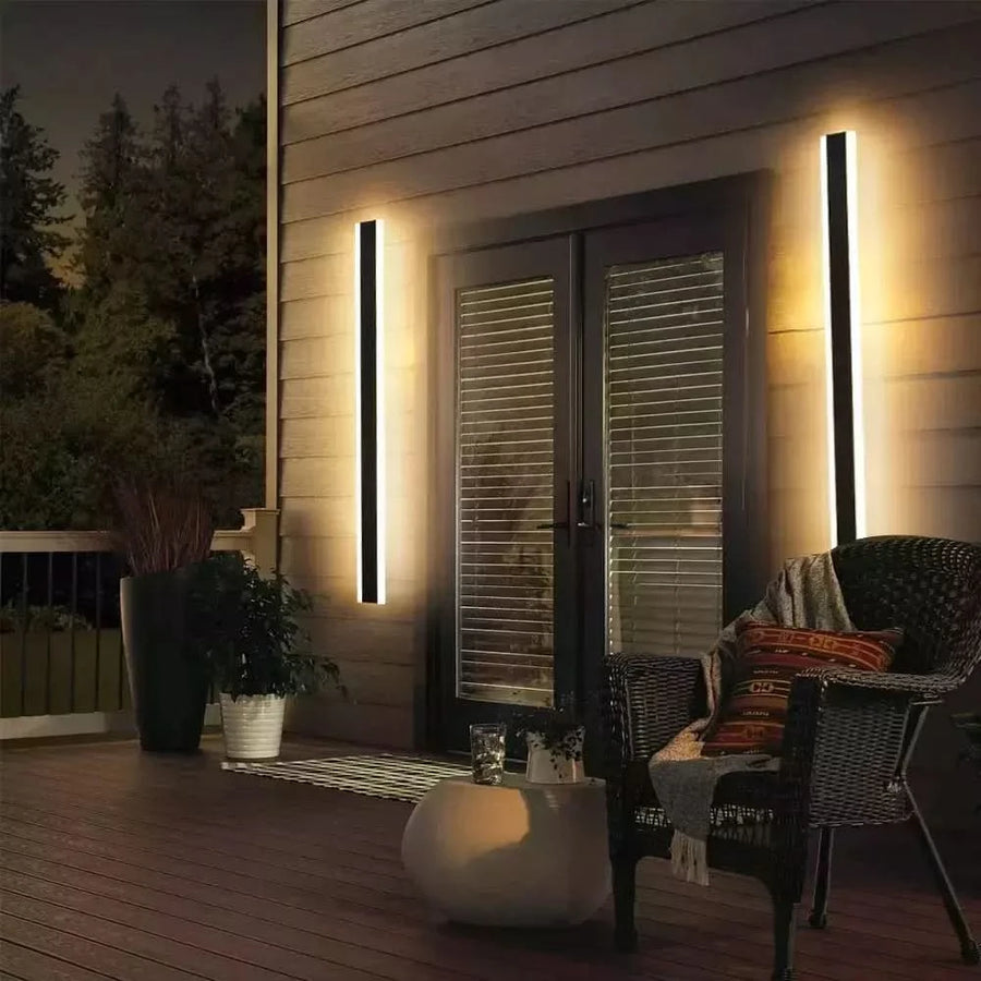 Deux appliques linéaires encadrant une porte-fenêtre sur une terrasse en bois