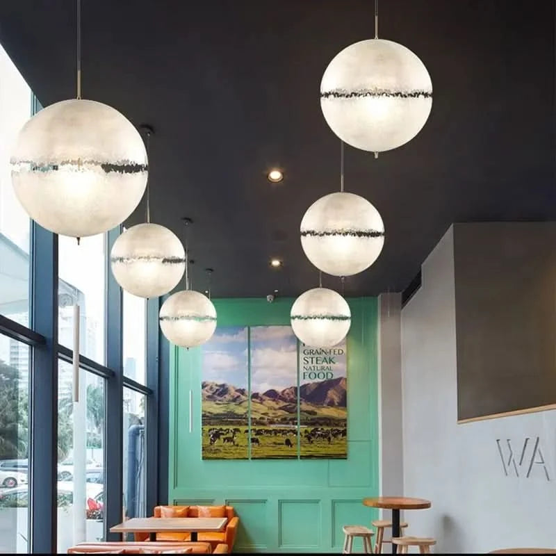 Plusieurs suspensions boules blanches alignées au plafond d'un café