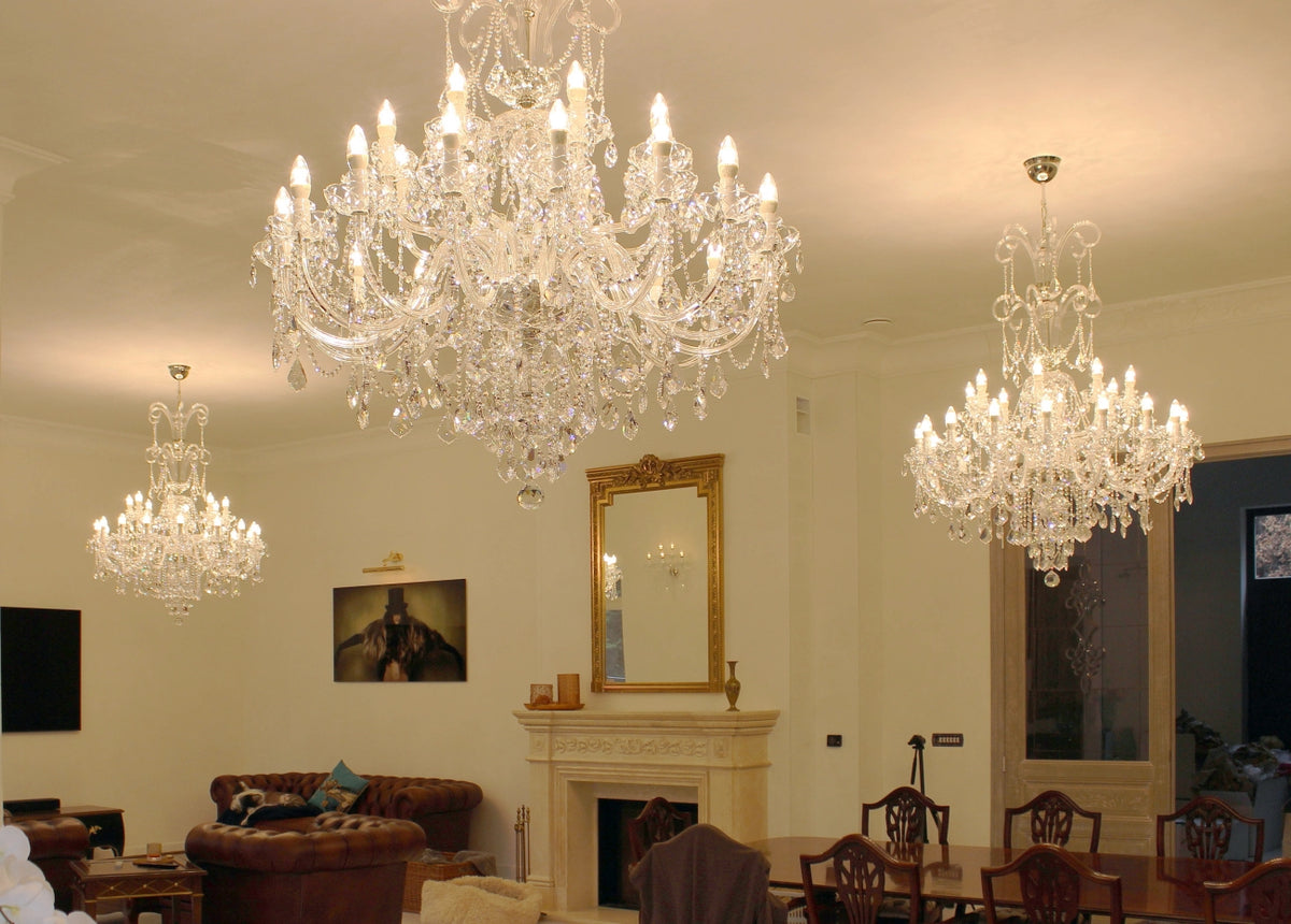 Lustre en cristal suspendu au plafond dans un salon avec cheminée et canapé en cuir