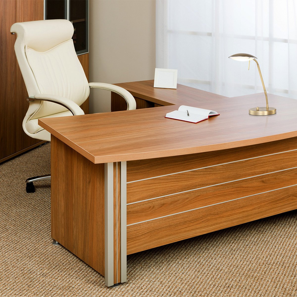 Lampe allumée posée sur un bureau en bois devant une chaise de bureau