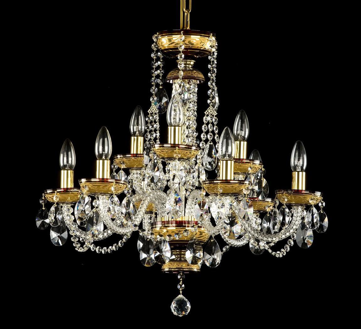 Lustre doré à huit bras vu de face sur fond noir, cristaux taillés