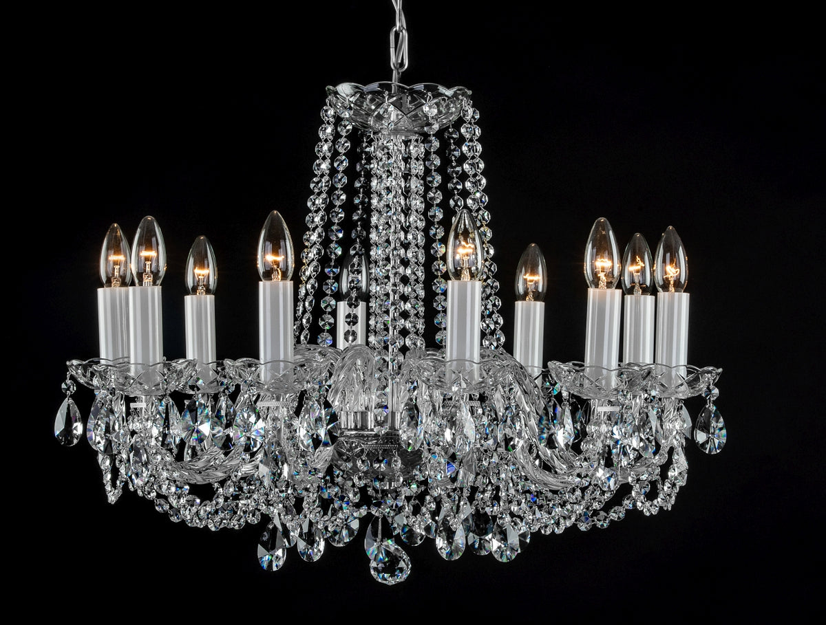Vue de face du lustre cristal avec ses ampoules allumées et ses chaînes de cristal.