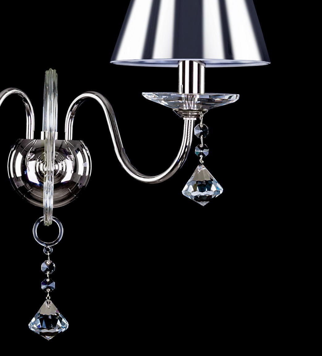 Détail gros plan d'un bras courbe, douille, coupelle cristal et pendentif taillé