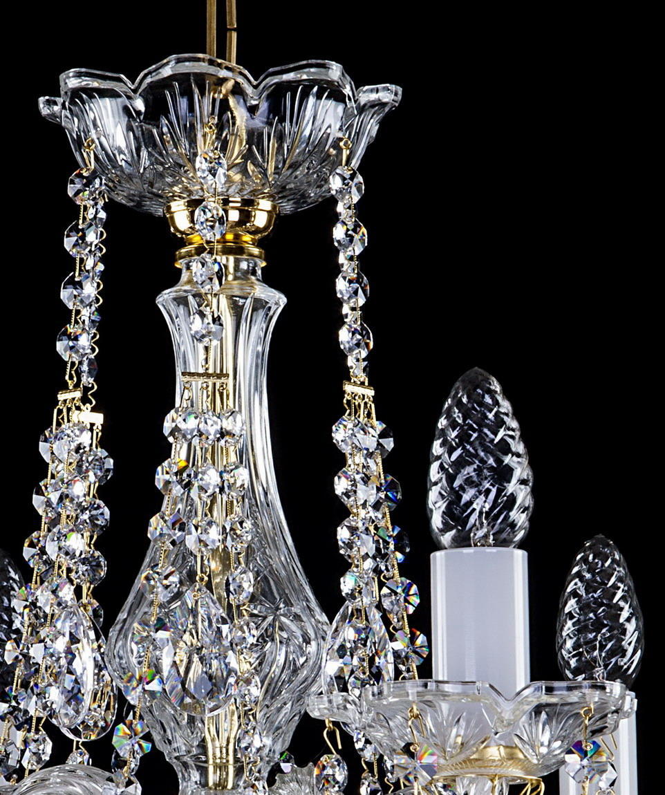 Gros plan sur la colonne centrale en verre taillé et les chaînettes de cristal doré.