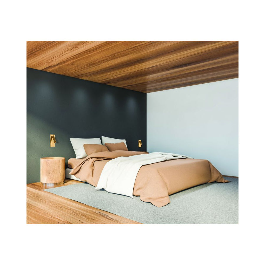 Mise en situation dans une chambre avec deux appliques murales allumées de chaque côté du lit.