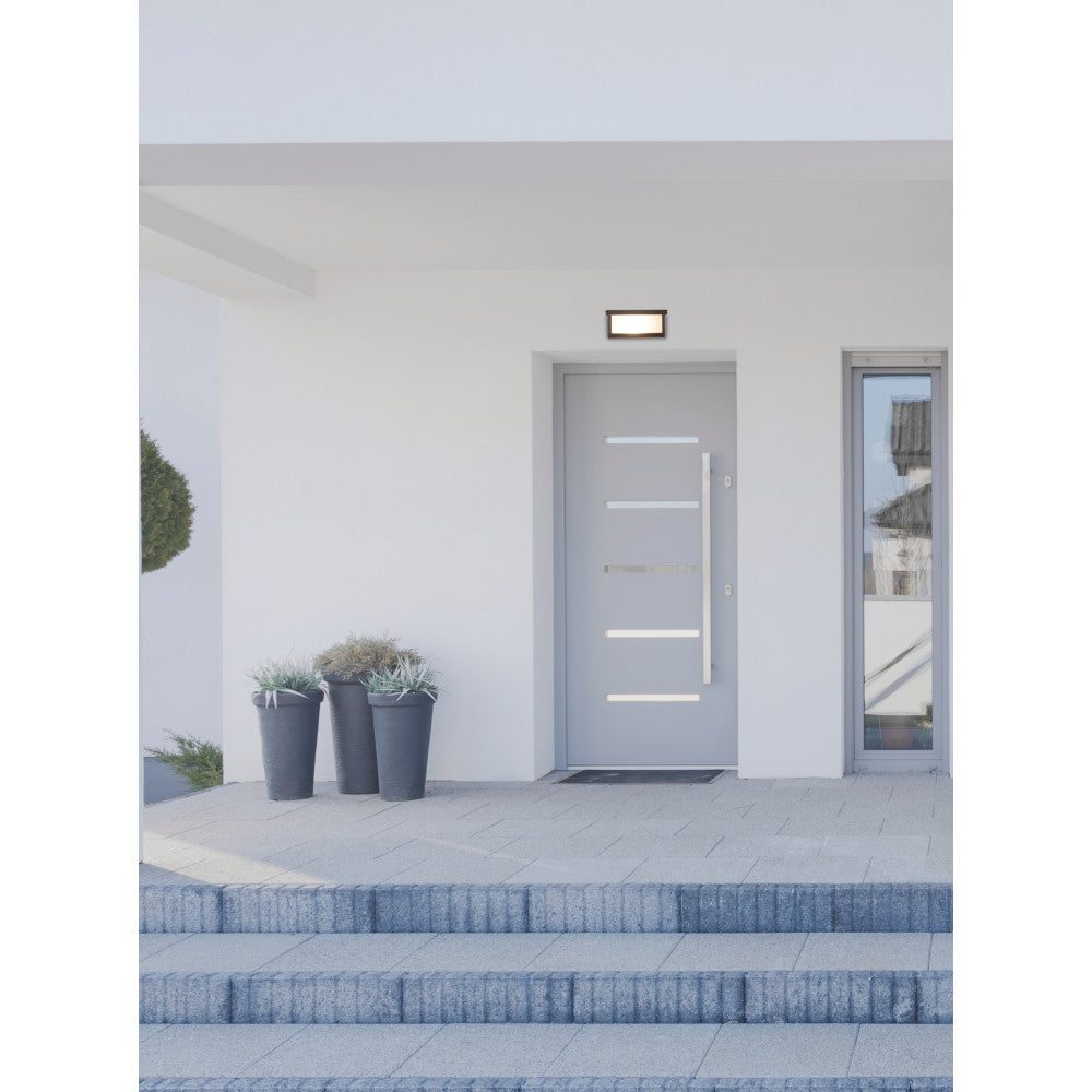 Mise en ambiance de l'applique murale au-dessus d'une porte d'entrée moderne.