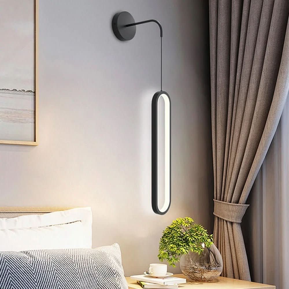 Applique murale noire fixée au mur, anneau LED ovale suspendu, chambre avec lit et rideaux.