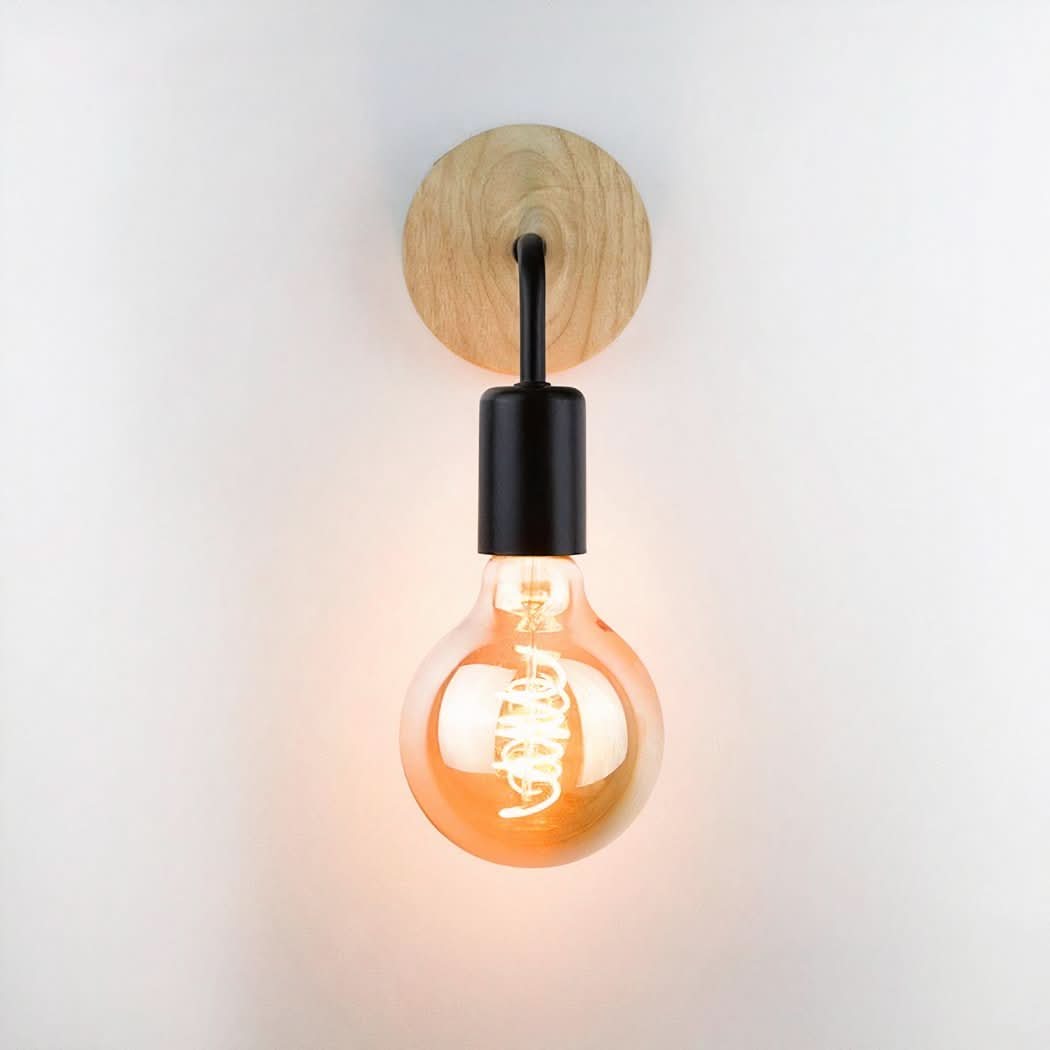 Applique murale de face sur fond blanc, ampoule globe allumée, base ronde en bois.