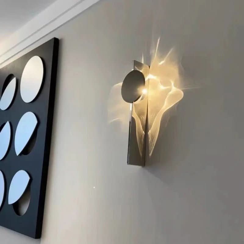 Applique murale installée près d'une œuvre graphique, éclairage chaud.