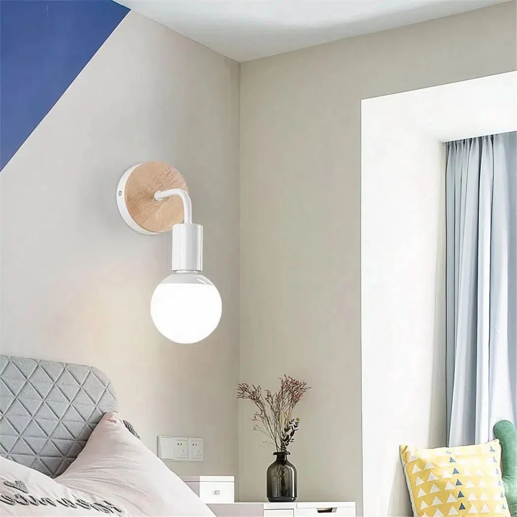 Mise en ambiance chambre avec applique allumée au-dessus du lit et décor