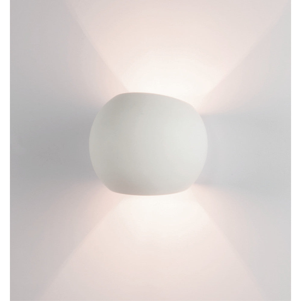 Applique murale blanche de face sur mur clair, halo lumineux haut et bas
