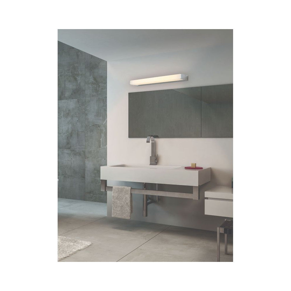 Mise en ambiance salle de bain, applique allumée fixée au-dessus d'un miroir et d'un lavabo