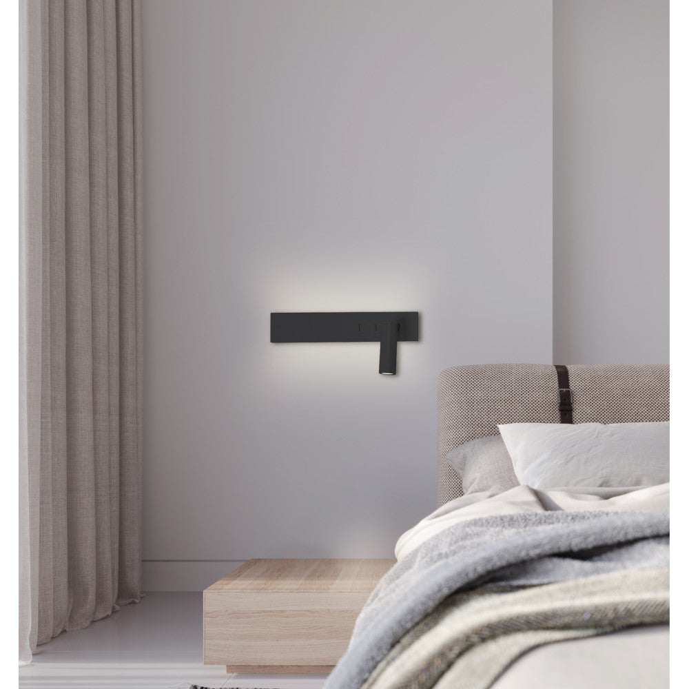 Applique noire fixée au mur au-dessus d'une tête de lit, lumière douce.