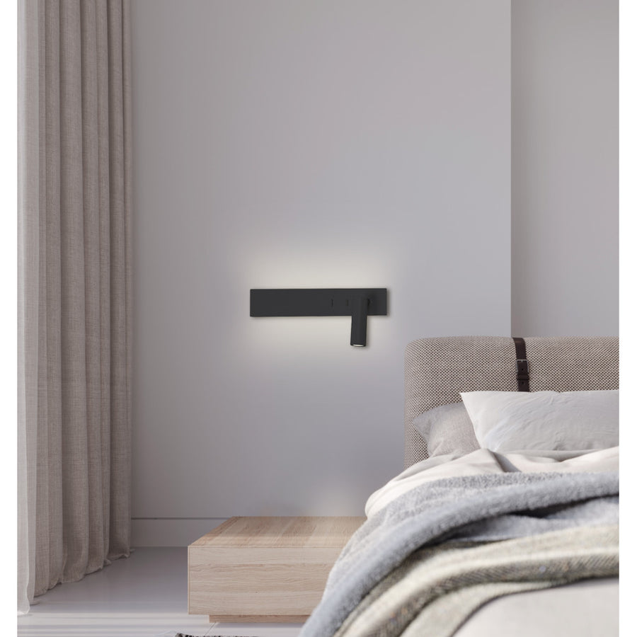 Applique noire fixée au mur au-dessus d'une tête de lit, lumière douce.
