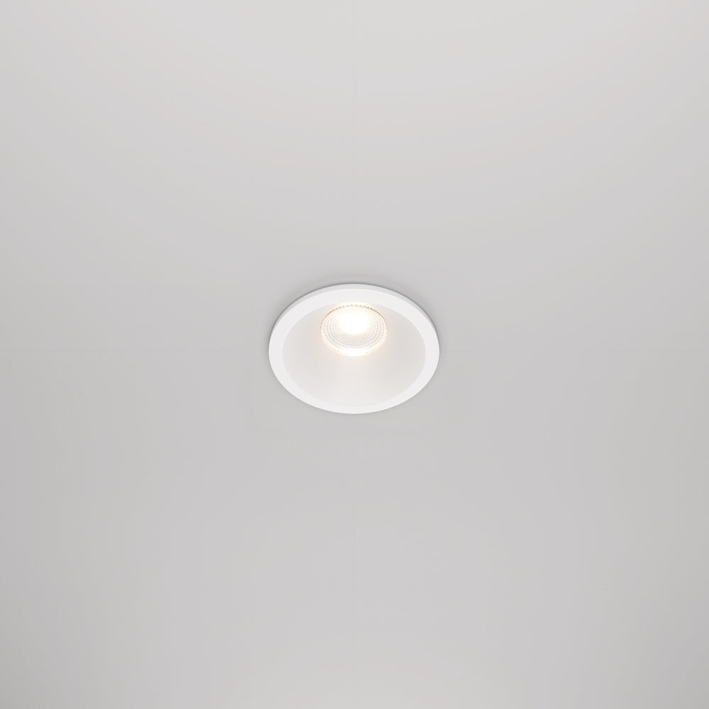 Spot encastré rond blanc vu de face, intégré dans un plafond lisse et clair.