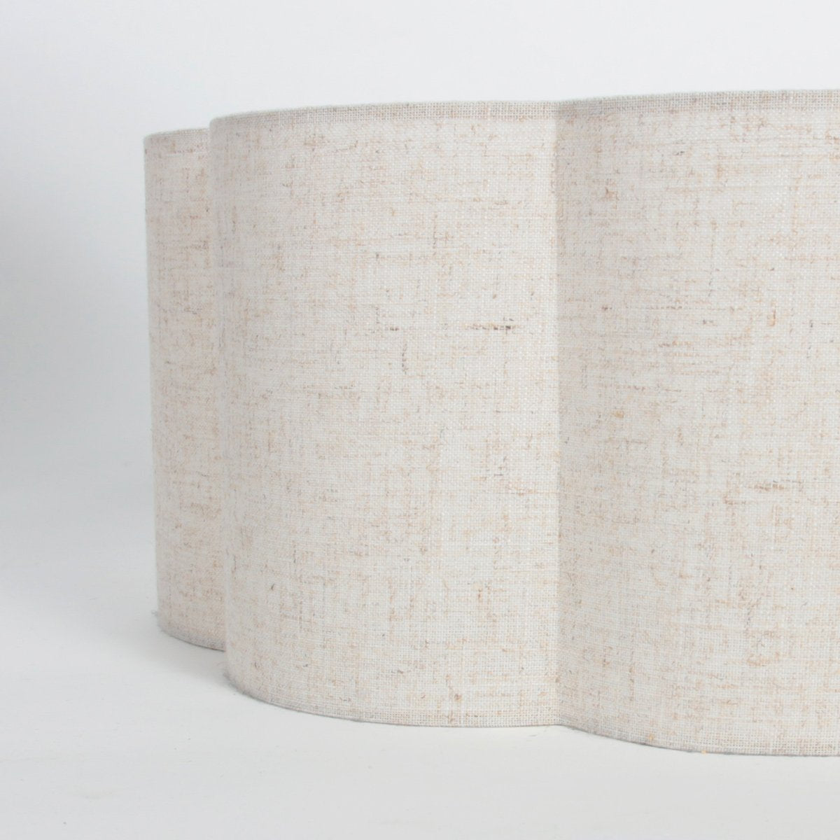 Détail de l'abat-jour crème, tissu texturé et bord festonné en forme de fleur