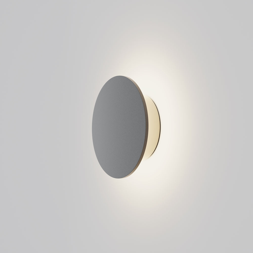 Applique murale ronde grise fixée au mur, halo lumineux diffusé tout autour