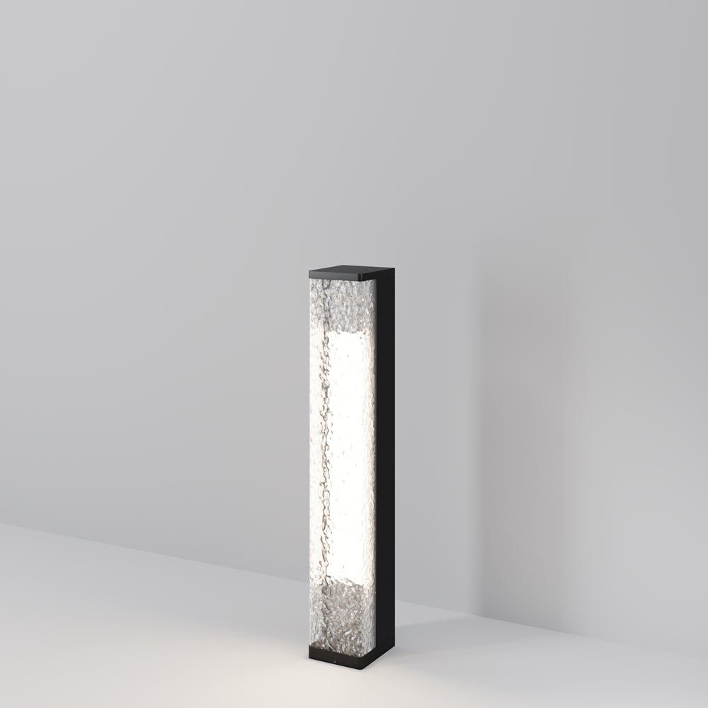 Borne lumineuse extérieure noire rectangulaire debout, verre martelé et base posée au sol.
