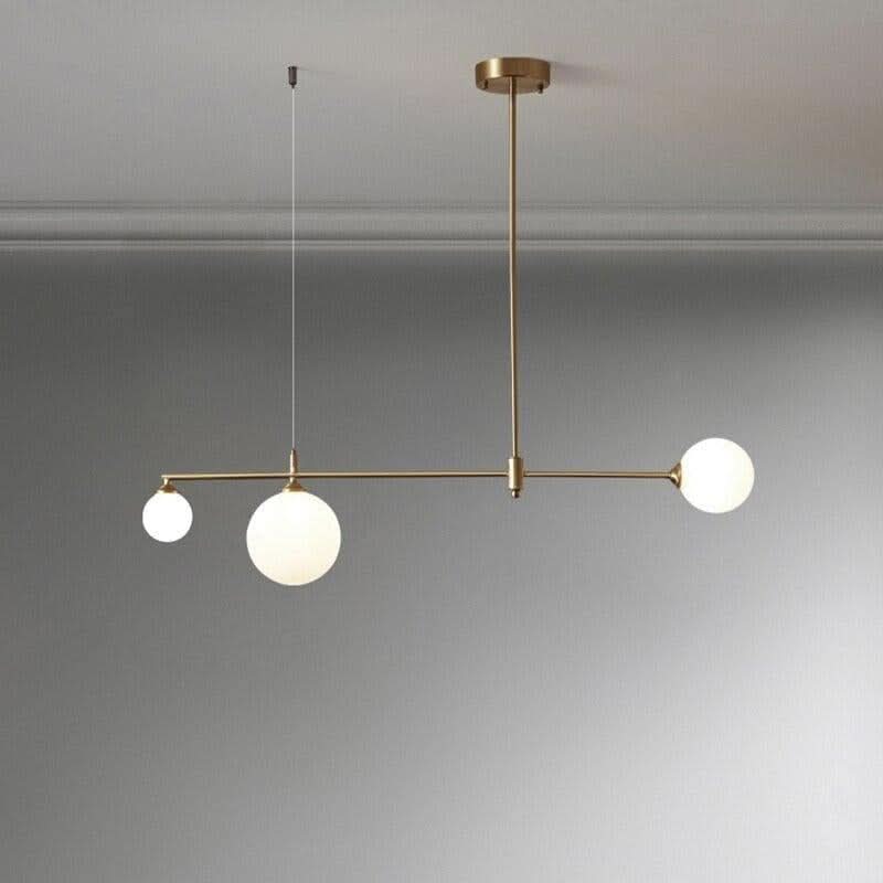 Vue produit du luminaire laiton avec trois boules de verre opalin sur tige centrale
