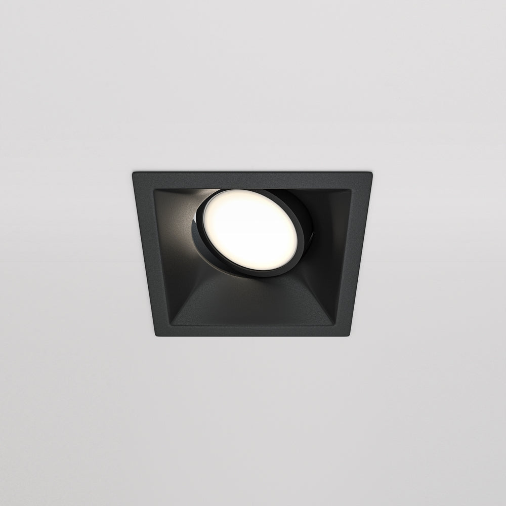 Spot encastré carré noir de face, diffuseur rond allumé sur plafond blanc