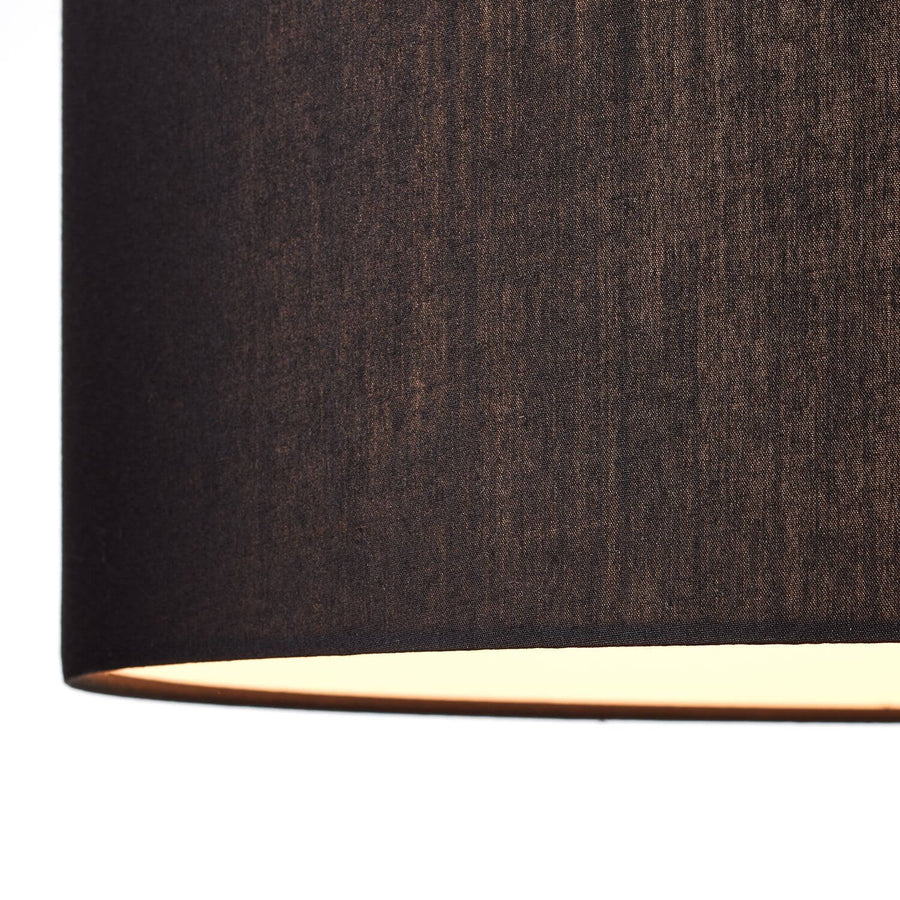 Détail de la texture tissée de l'abat-jour noir éclairé par le bas