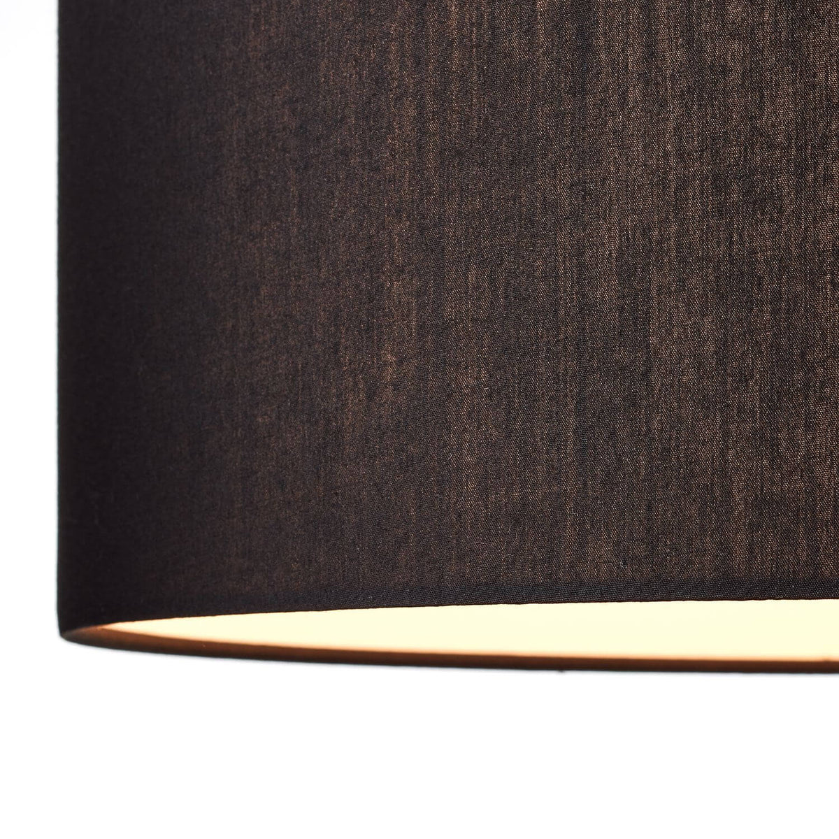 Détail de la texture tissée de l'abat-jour noir éclairé par le bas