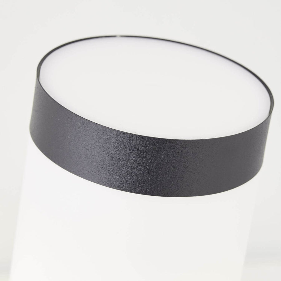 Gros plan sur le bandeau noir supérieur et le bord du diffuseur blanc