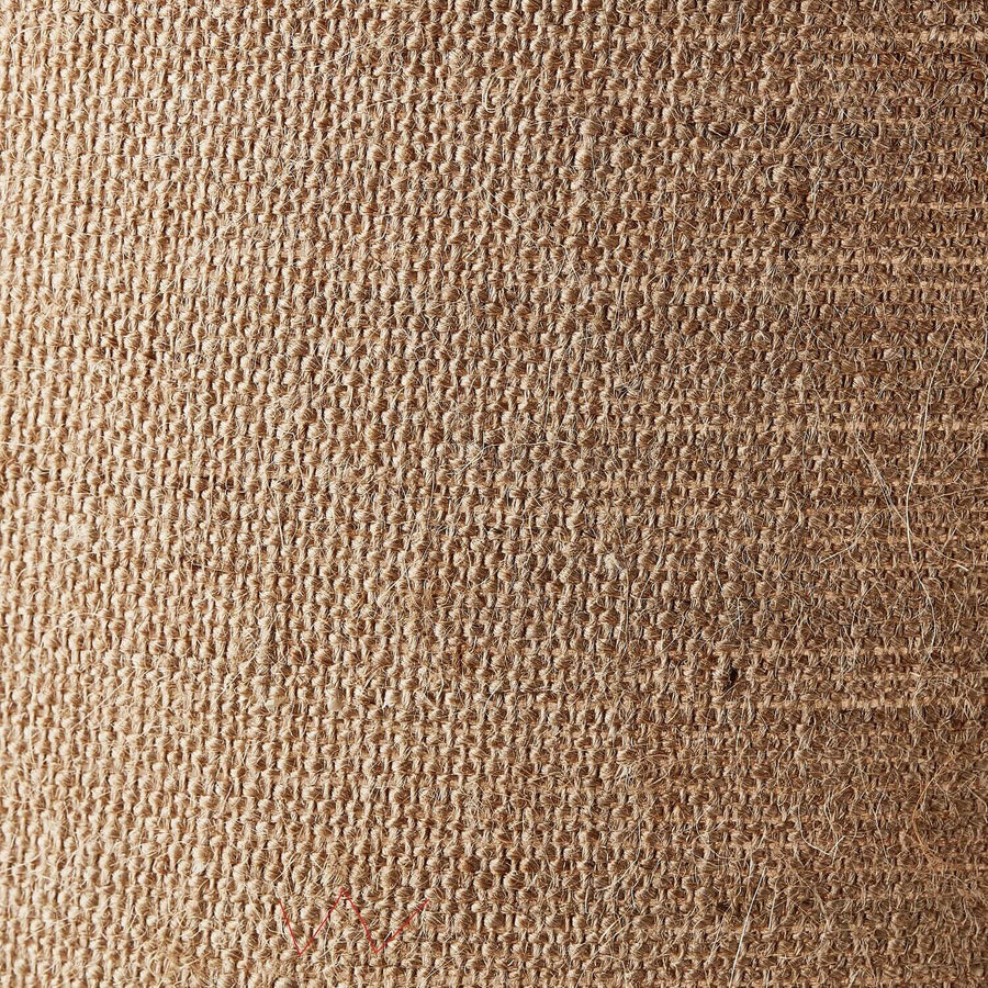 Gros plan sur la texture tissée beige et rugueuse de l'abat-jour en fibres