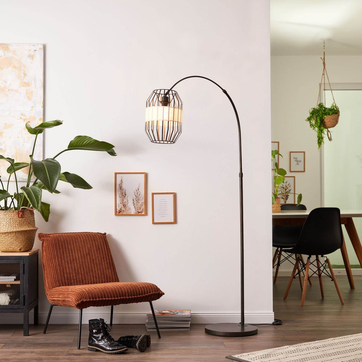 Lampadaire à arc allumé dans un salon avec plantes vertes et cadres