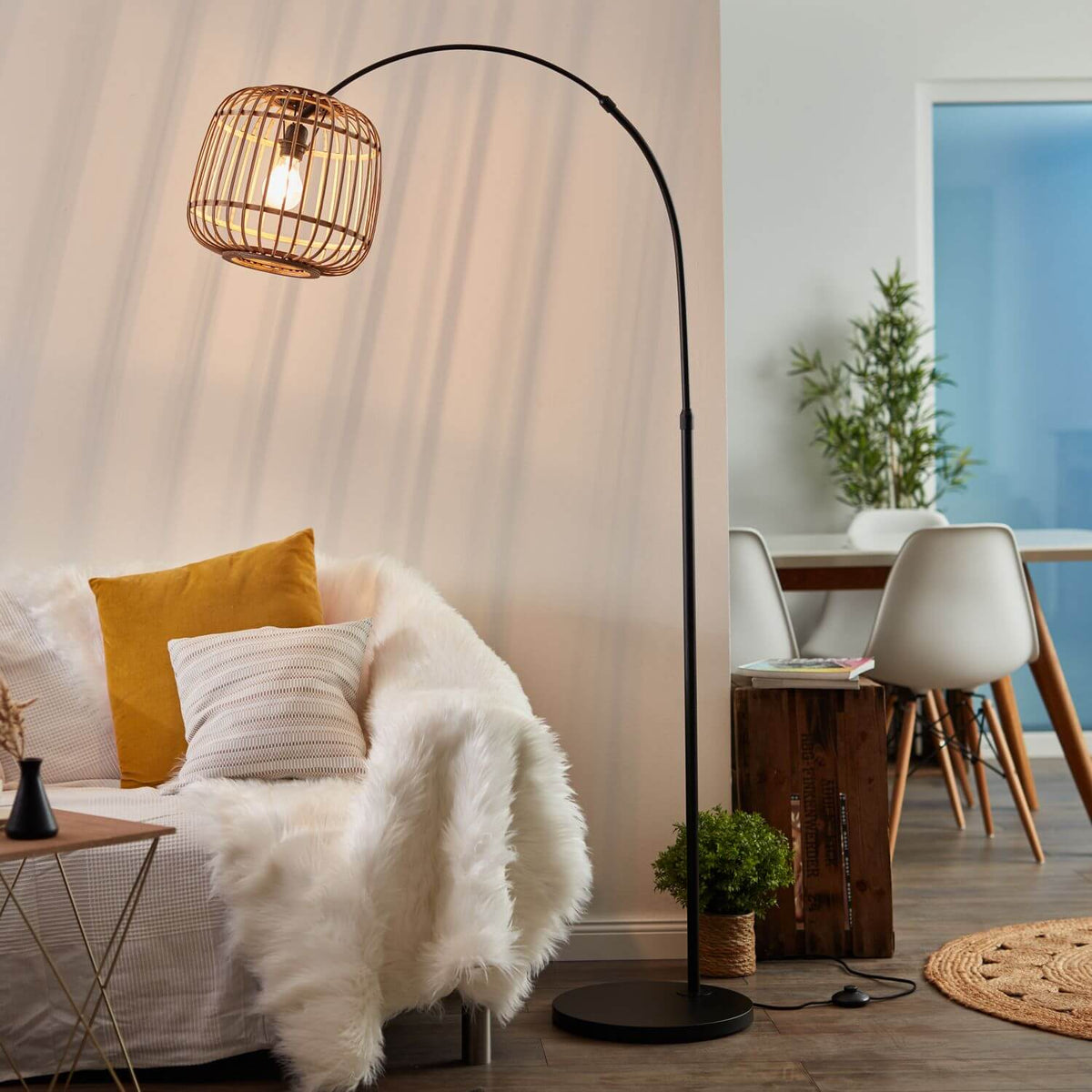 Lampadaire allumé dans un salon cosy, canapé blanc et coussins jaunes, ambiance chaleureuse.