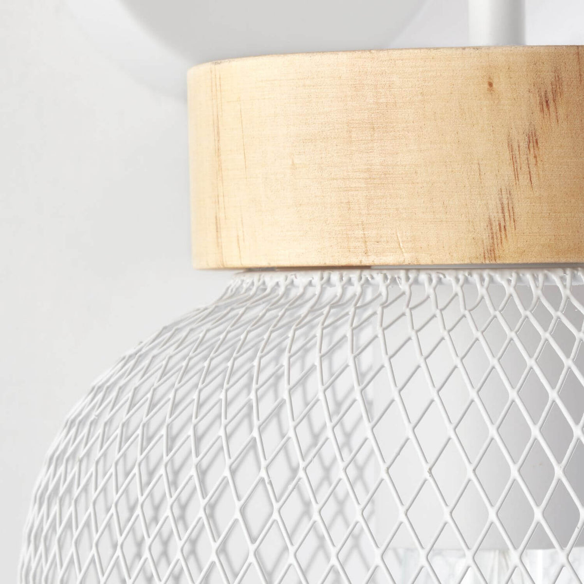 Détail de la finition : cerclage en bois clair et maille diamantée blanche de l'abat-jour