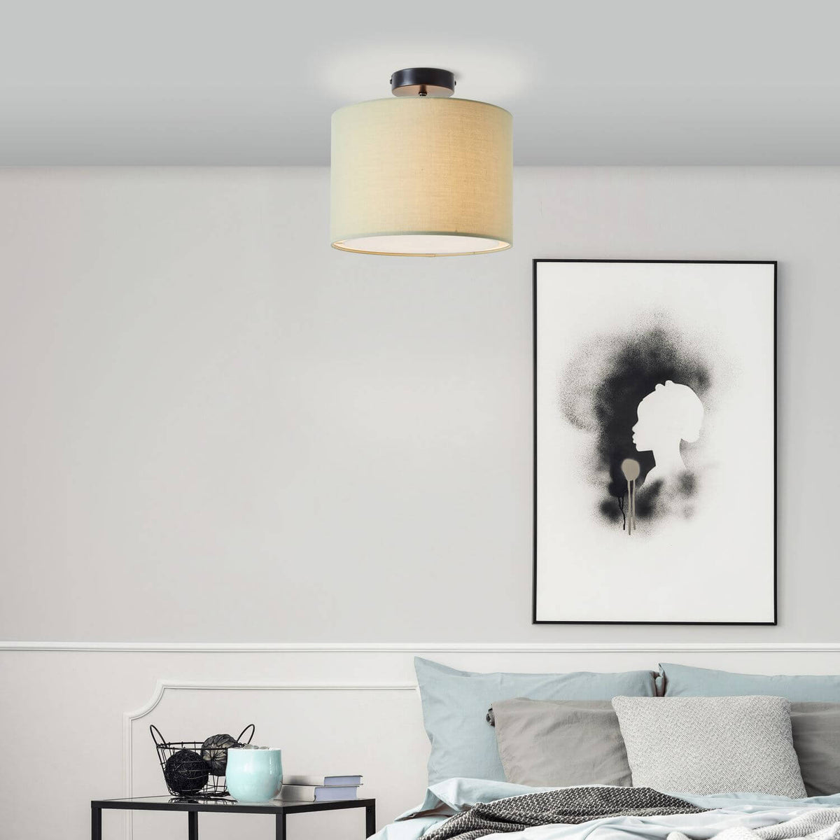 Mise en ambiance dans une chambre, luminaire allumé au-dessus du lit et d'une table de nuit