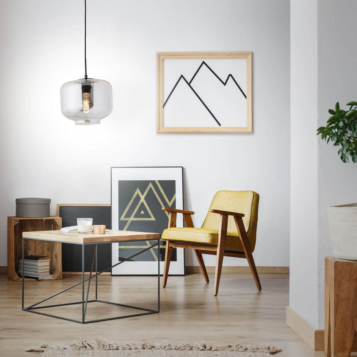 Vue d'ensemble du salon avec la suspension allumée, fauteuil jaune et cadres muraux