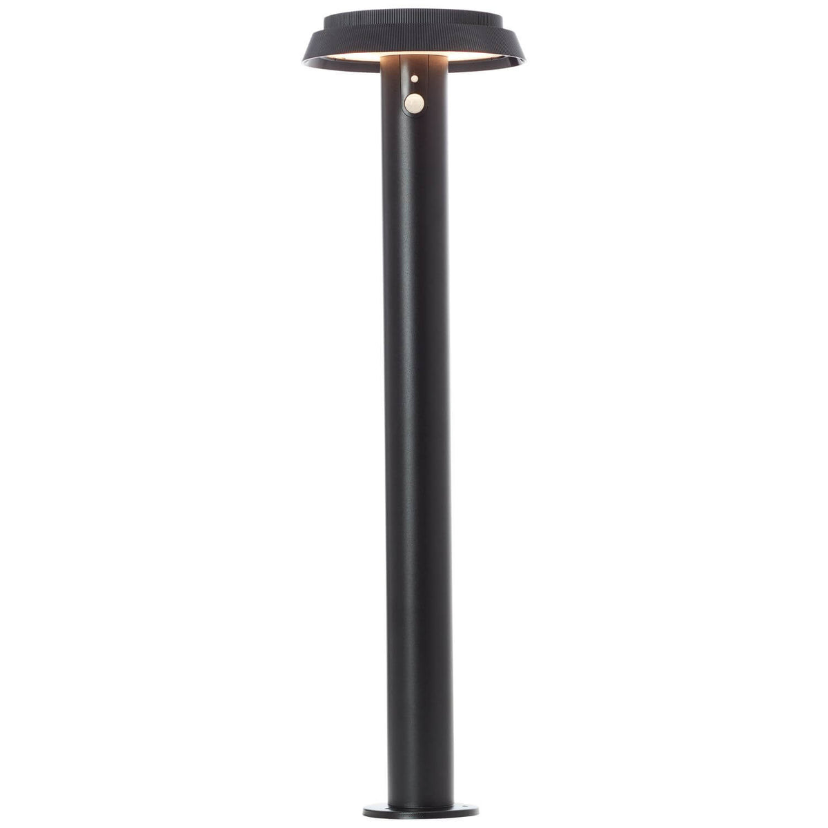 Lampadaire allumé de face, halo lumineux diffus sous le chapeau circulaire noir.
