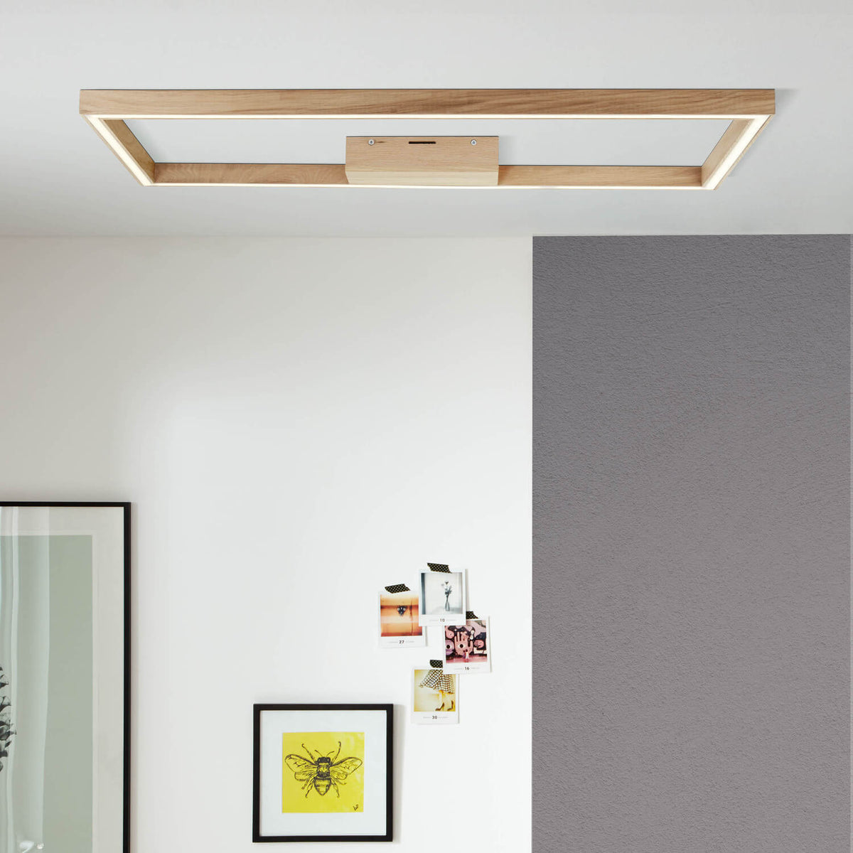 Plafonnier en bois fixé au plafond dans un intérieur contemporain éclairant un mur décoré
