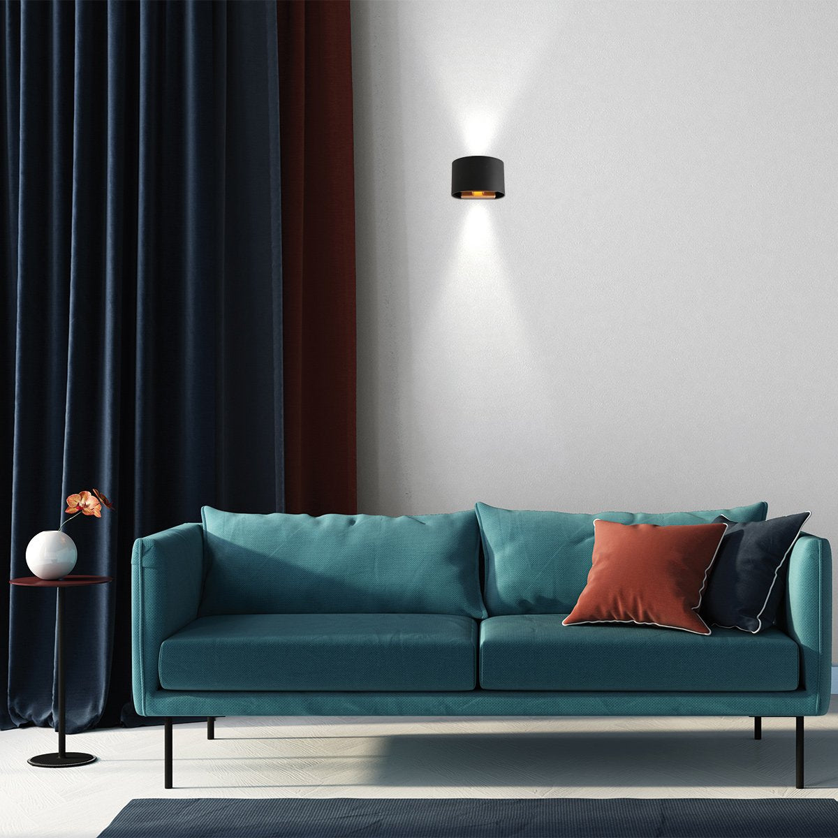 Mise en ambiance salon : applique noire allumée sur mur blanc au-dessus d'un canapé.