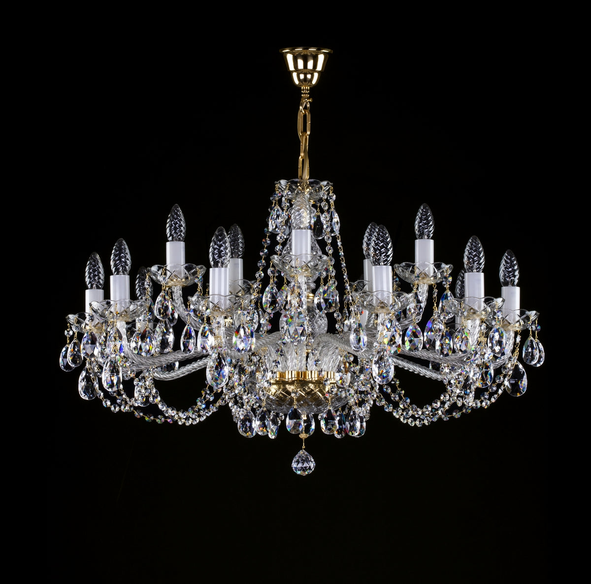Lustre en cristal à monture dorée et nombreuses pampilles, vu de face sur fond noir.