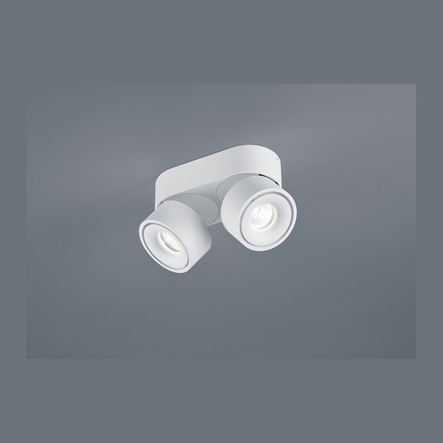 Vue de face d'un plafonnier blanc à deux spots cylindriques orientables sur socle central