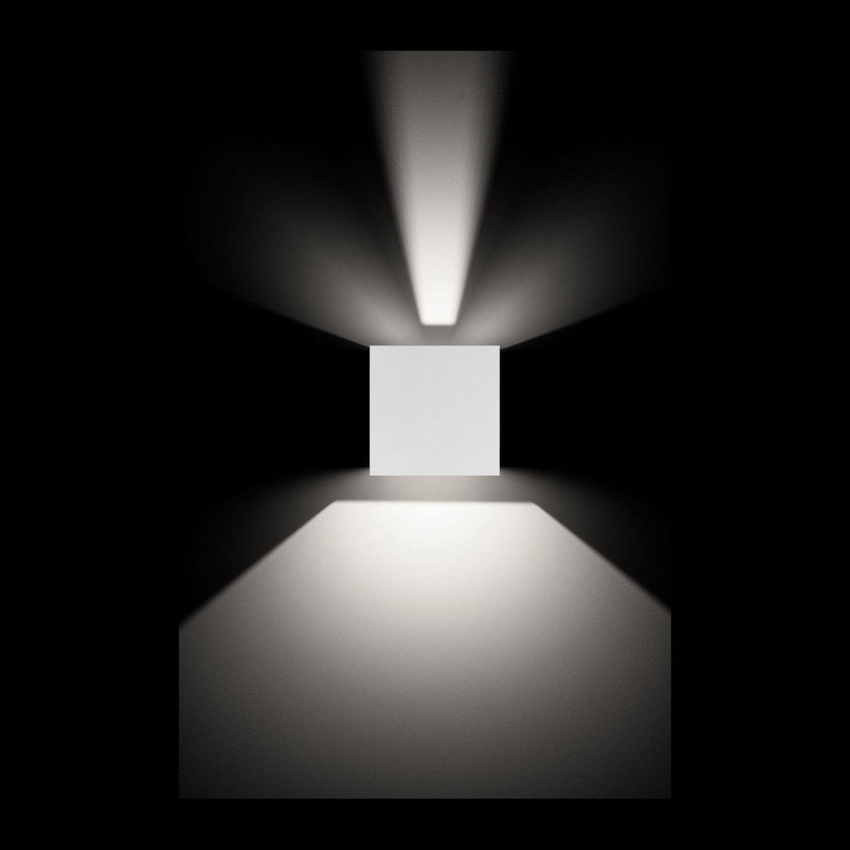 Applique murale blanche éclairant un mur sombre, faisceaux lumineux vers le haut et le bas