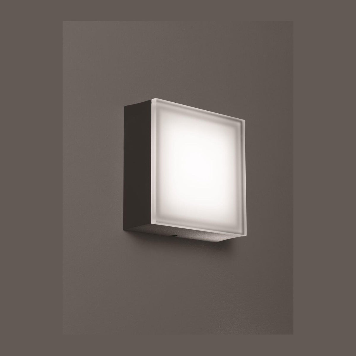 Vue de trois quarts du luminaire allumé sur fond gris foncé uniforme