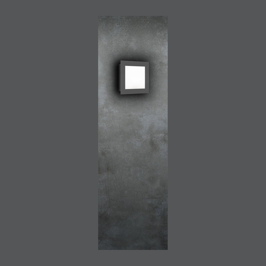 Applique murale carrée anthracite allumée, fixée sur un mur en béton gris