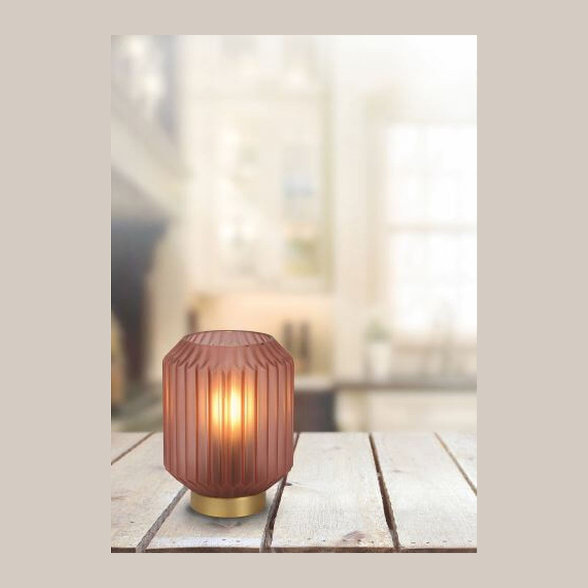 Mise en ambiance : lampe à poser allumée sur table en bois, intérieur flou en arrière-plan.