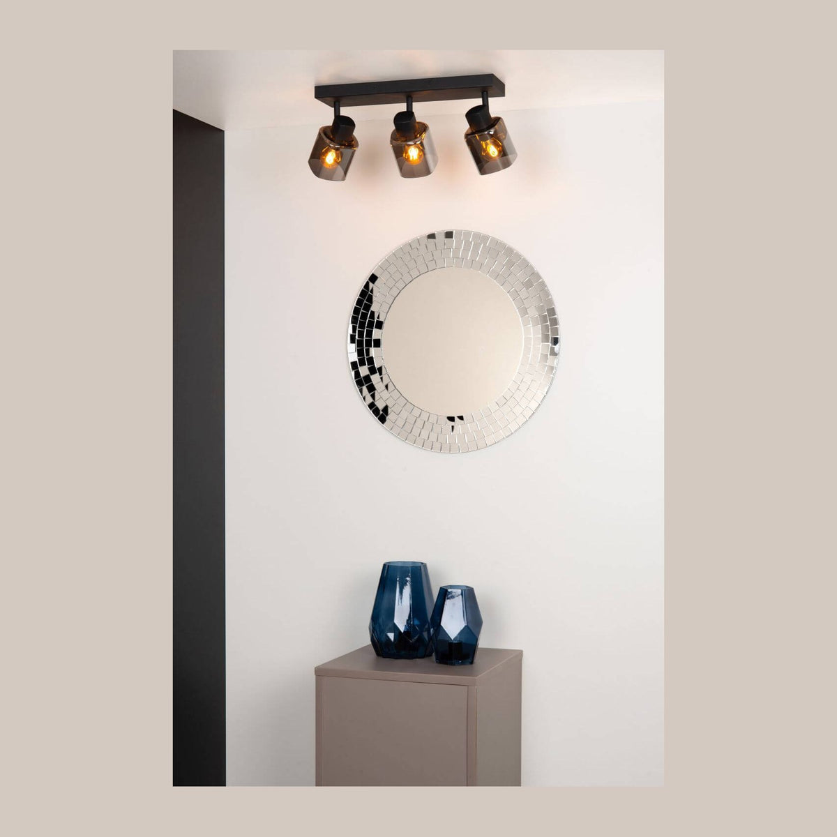 Mise en ambiance du plafonnier trois spots noirs au-dessus d'un miroir rond