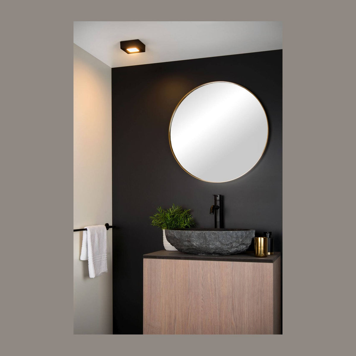 Plafonnier noir carré allumé au plafond, ambiance salle de bain sombre et moderne