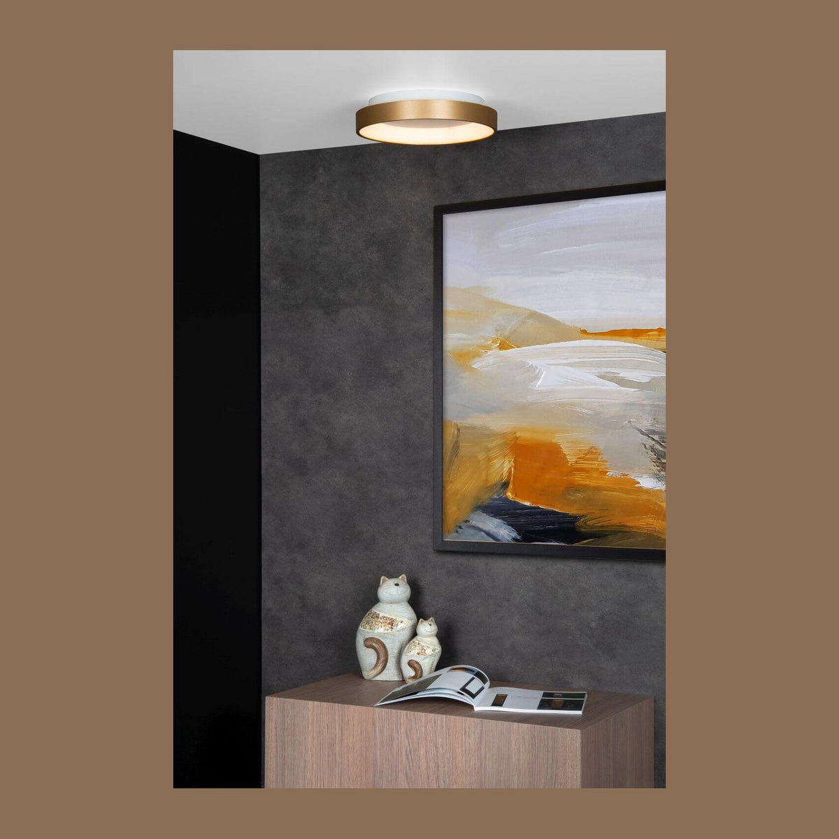 Plafonnier doré mat allumé au plafond dans un intérieur gris contemporain