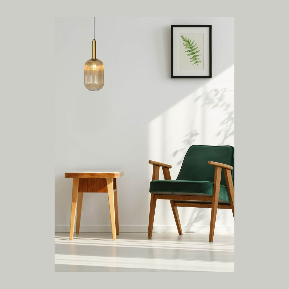 Suspension allumée dans un salon avec fauteuil vert et table en bois